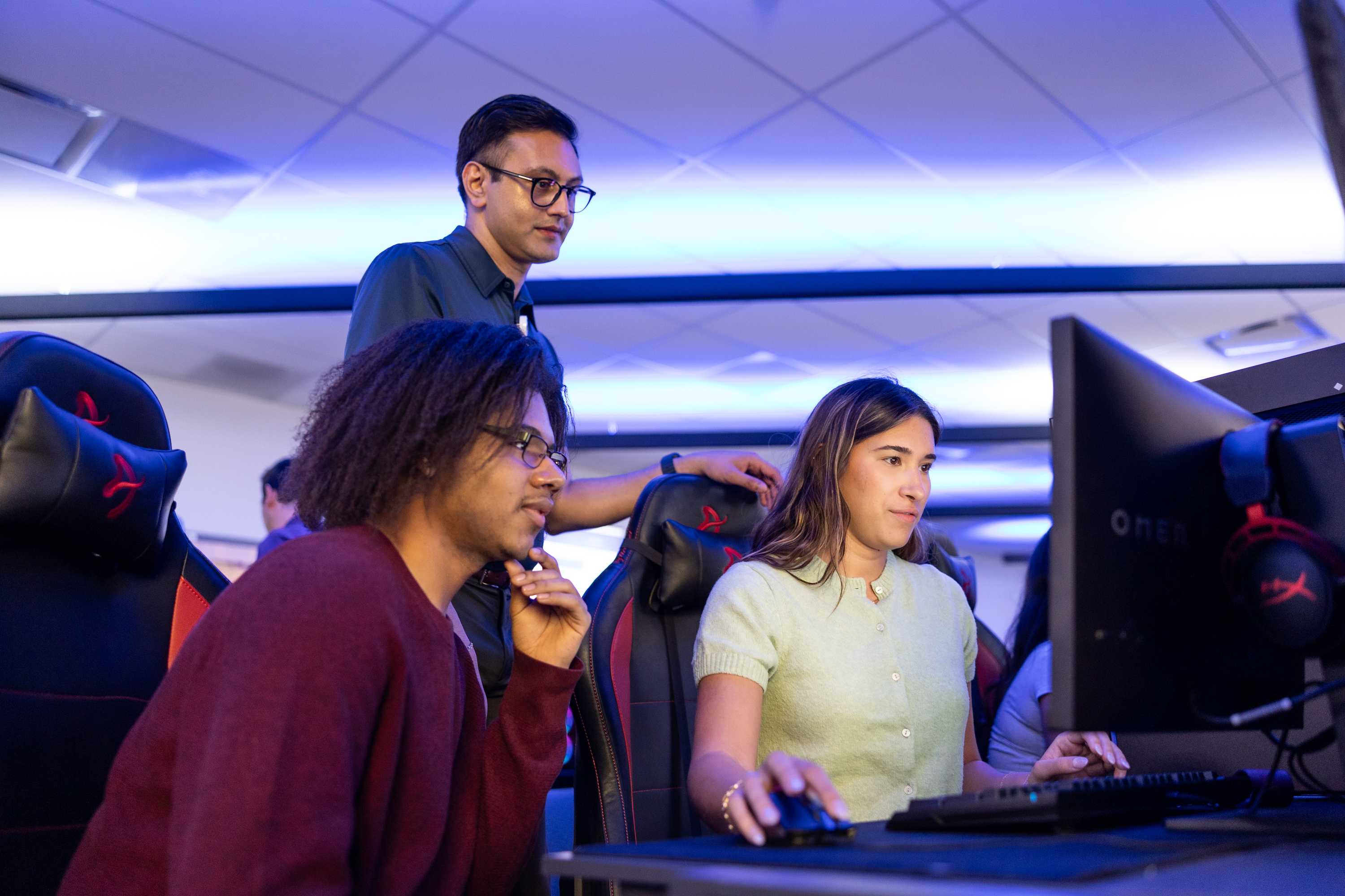 three CareerCatalyst learners looking at a computer screen